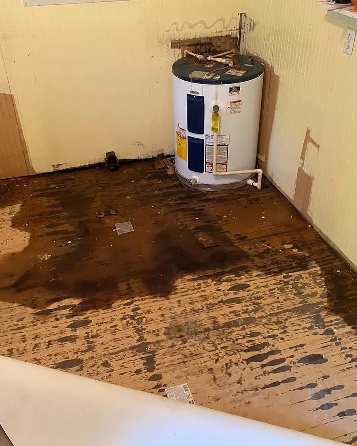 Water spreading across a garage floor from a failed water heater tank in Statham, GA